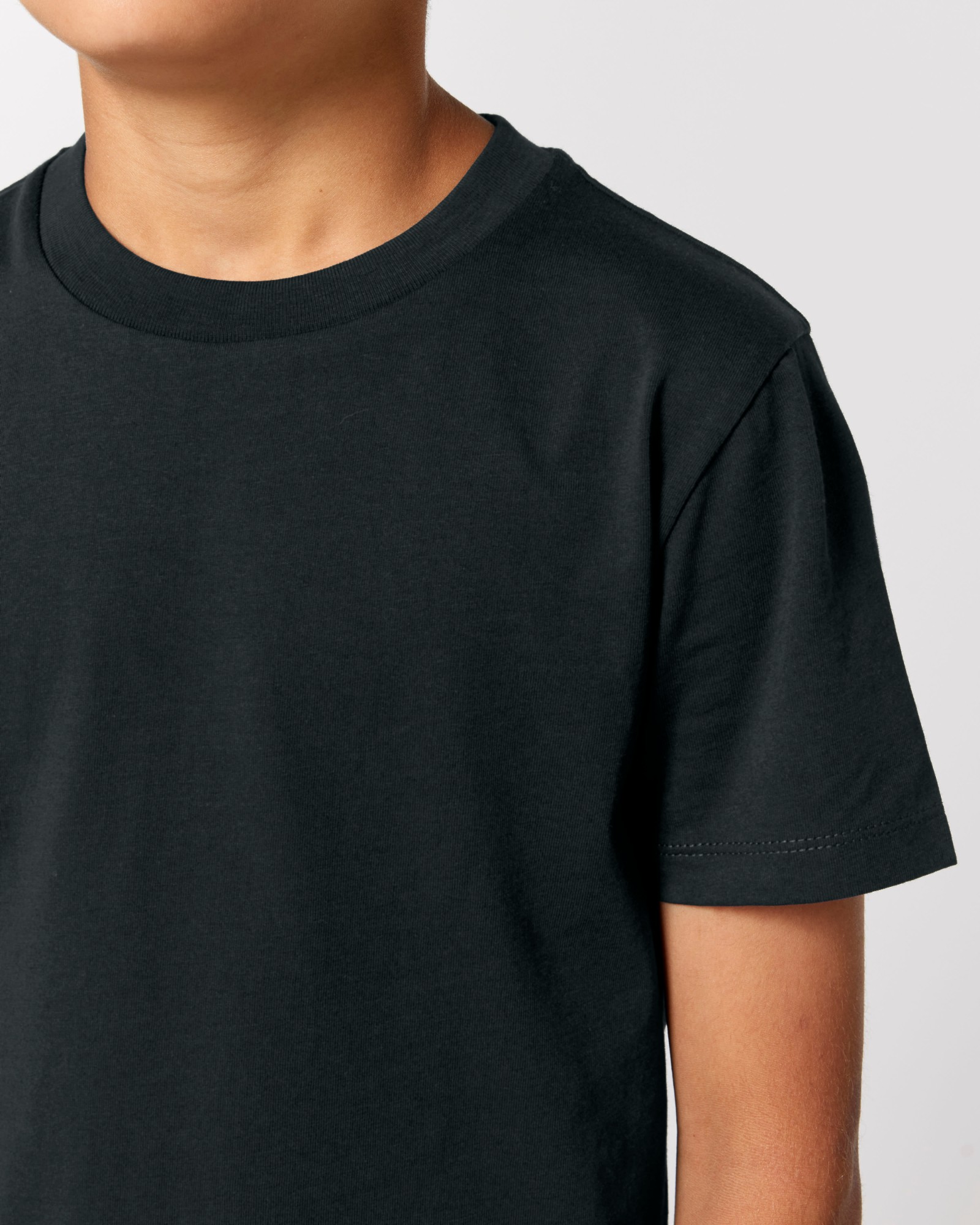 T-shirt enfant noir en coton bio, porté — personnalisable chez Teeshirt-minute